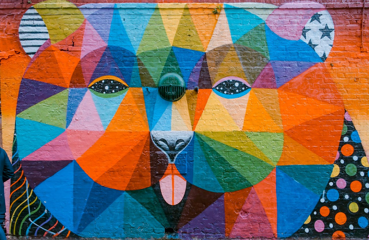 selective-photograph-of-a-wall-with-grafitti-1194420 Vibrant geometric mural of a bear on a brick wall in London, showcasing diverse colors and artistic flair.