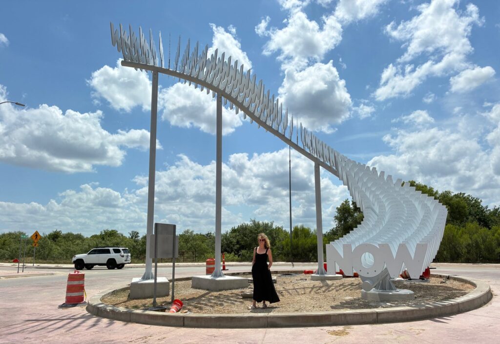Alicia Eggert stands in front of sculpture